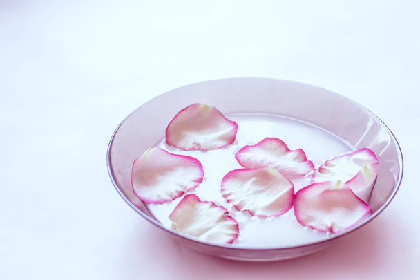 Pétales de rose dans le lait. Lait avec pétales dans une assiette. Aromathérapie
 - Photo, image
