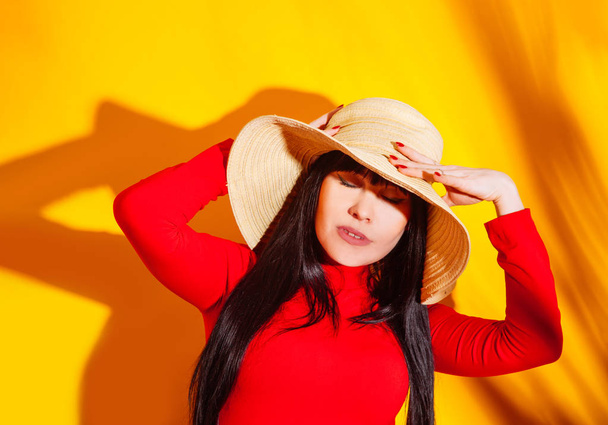girl straw hat sun sunglasses light shadow tropical yellow orange young woman background red t-shirt - Photo, Image