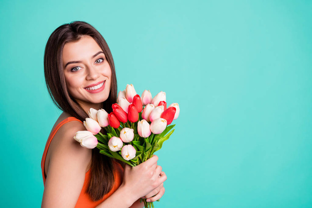 Close up side profile photo beautiful amazing her she lady hands arms fresh flowers white red tulips surprise anniversary birthday wear casual orange tank-top isolated bright teal turquoise background - Valokuva, kuva