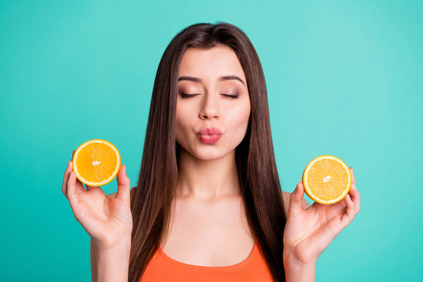 Close up photo beautiful her she lady hold arms citrus useful slices products advertising nutrition fresh send air kiss ideal lips wear casual orange tank-top isolated bright teal turquoise background - Foto, imagen