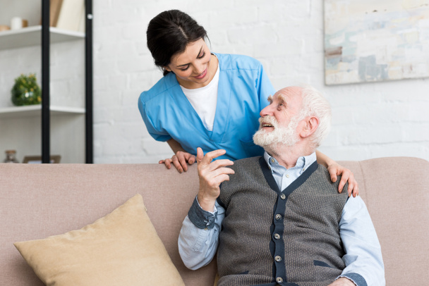 Médecin debout derrière un homme âgé, parlant à un patient heureux
 - Photo, image