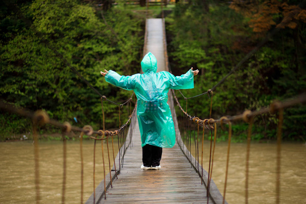 森林ハイキングでヒンジ付き橋で60歳のシニア女性クロッシング川 - 写真・画像