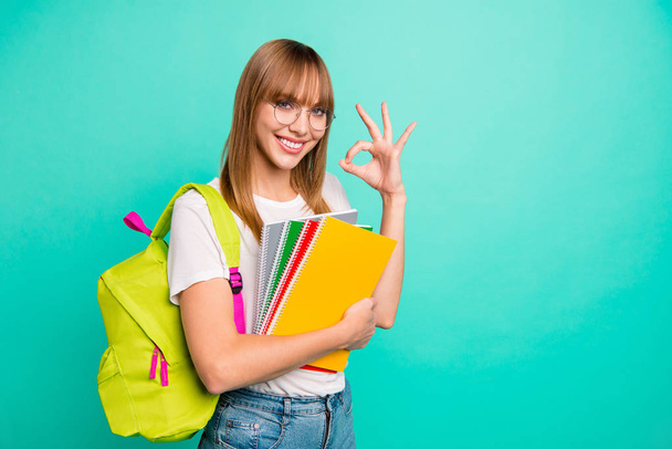 Close up photo amazing beautiful she her lady hold arms hands school colored notebooks okey symbol last year studying science genius wear specs casual white t-shirt isolated teal green background - Φωτογραφία, εικόνα