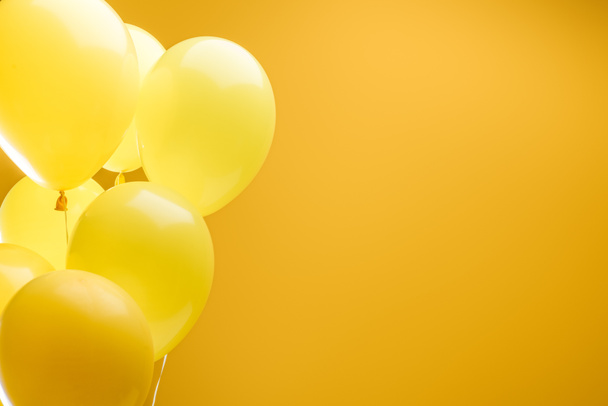 festive bright minimalistic decorative balloons on yellow background with copy space - Фото, зображення