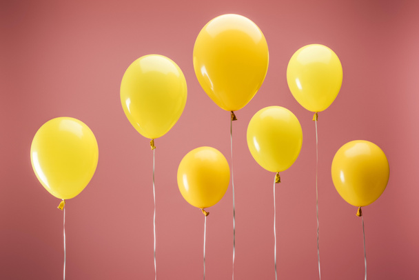 yellow balloons on pink background, party decoration - Fotó, kép