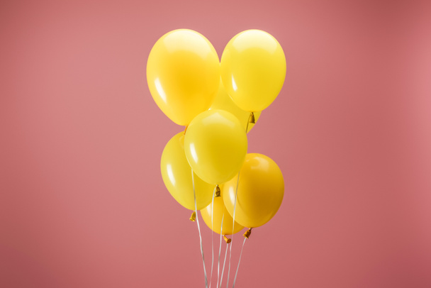 yellow bright balloons on pink background, party decoration - Φωτογραφία, εικόνα