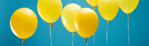 bright party yellow balloons on blue background, panoramic shot - Foto, imagen