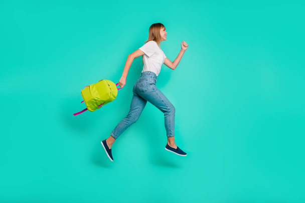 Full length side profile body size photo beautiful she her lady weekend vacation jump high arms hands back pack on way home wear specs casual jeans denim white t-shirt isolated teal background - Foto, Imagen