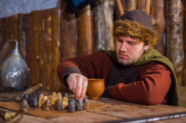 Portrait of man in russian ethnic suit playing chess - Photo, image