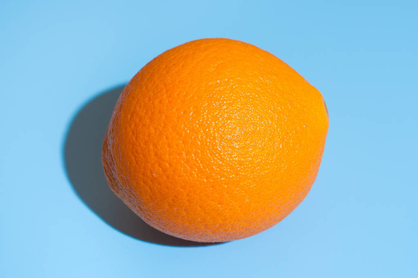 Ripe juicy orange on blue background. Healthy eating and dieting - Foto, Imagen