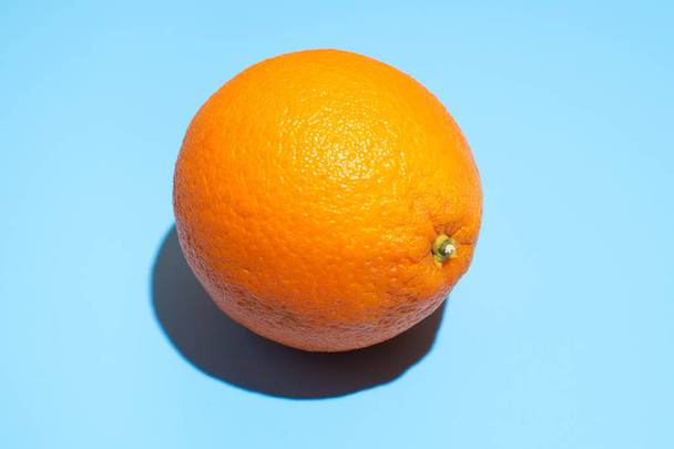 Ripe juicy orange on blue background. Healthy eating and dieting - Фото, зображення
