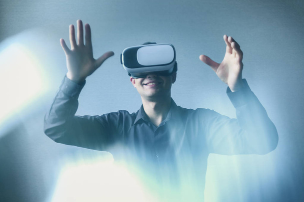 Молодой человек в виртуальных очках взаимодействует с виртуальной реальностью
 - Фото, изображение
