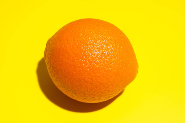 Ripe juicy orange on yellow background. Healthy eating and dieti - Foto, Imagen