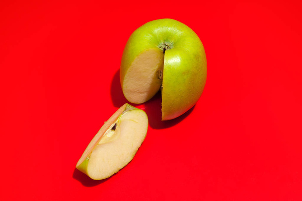 Ripe green cut apple Isolated on a red background. Healthy eatin - Foto, Imagen