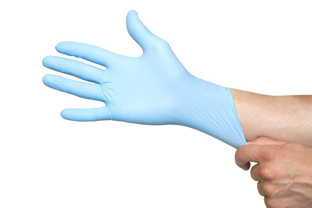 Doctor putting on protective blue gloves isolated on yellow back - Foto, immagini