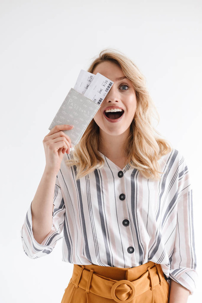 Portrait of smiling happy woman wearing casual clothes holding traveling tickets and passport - 写真・画像