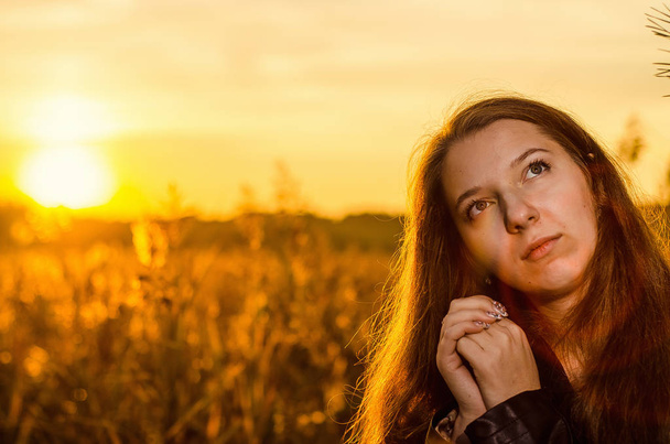 Beautiful girl in a posh red dress posing on a poppy field. Poppy field at sunset. Art processing. Sunset - Foto, Imagem