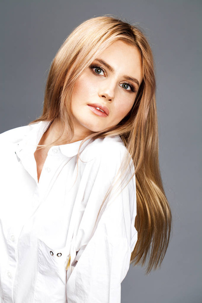 Closeup portrait of a young beautiful blonde woman in a white sh - Zdjęcie, obraz