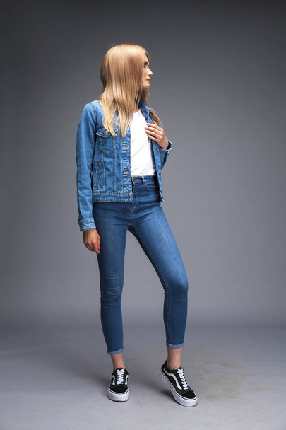 Beautiful sexy blonde woman dressed in a denim jacket and blue j - Foto, afbeelding