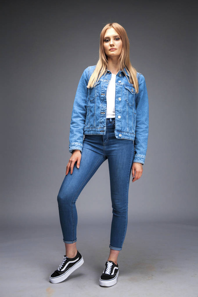 Beautiful sexy blonde woman dressed in a denim jacket and blue j - Valokuva, kuva