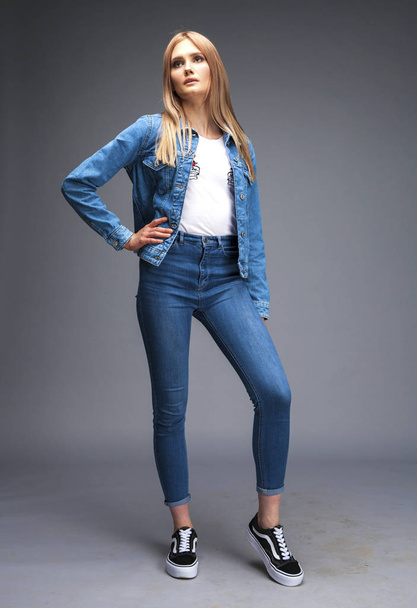 Beautiful sexy blonde woman dressed in a denim jacket and blue j - 写真・画像