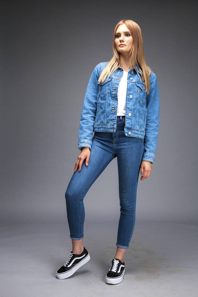 Beautiful sexy blonde woman dressed in a denim jacket and blue j - Foto, imagen