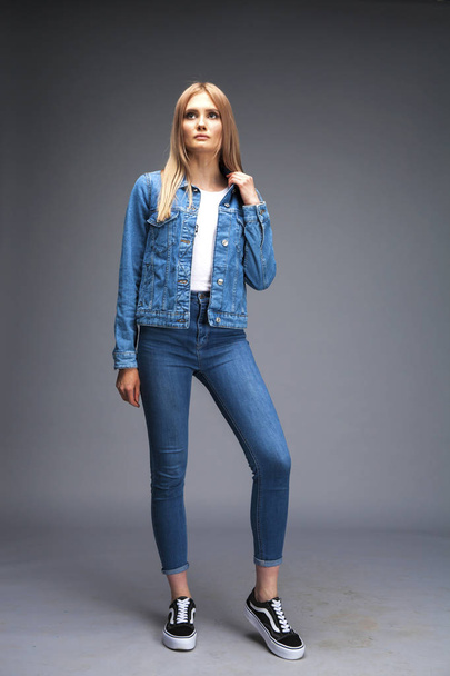 Beautiful sexy blonde woman dressed in a denim jacket and blue j - Foto, imagen