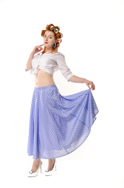 Redheaded girl in hair curlers in lilac skirt, a white topography and isolated on a white background - Foto, Imagen