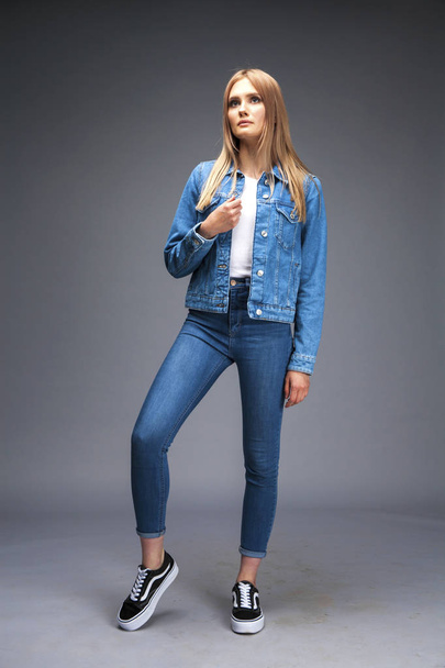 Beautiful sexy blonde woman dressed in a denim jacket and blue j - Foto, Imagem