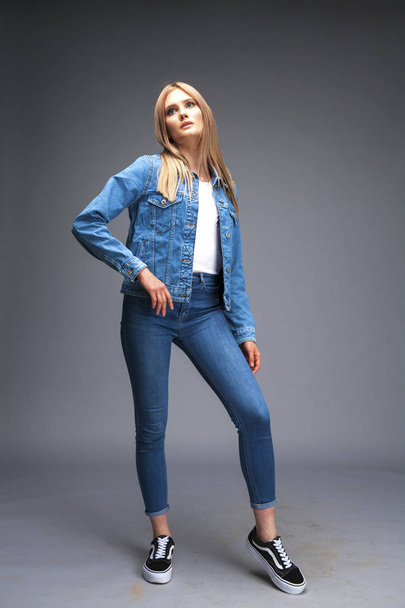 Beautiful sexy blonde woman dressed in a denim jacket and blue j - Foto, Imagem