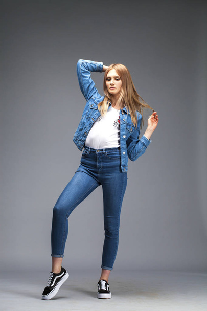 Beautiful sexy blonde woman dressed in a denim jacket and blue j - Foto, afbeelding