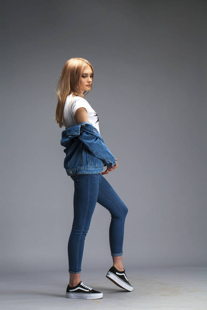 Beautiful sexy blonde woman dressed in a denim jacket and blue j - Фото, изображение