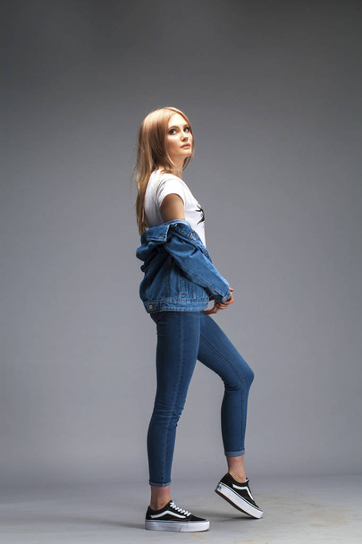 Beautiful sexy blonde woman dressed in a denim jacket and blue j - Foto, Bild