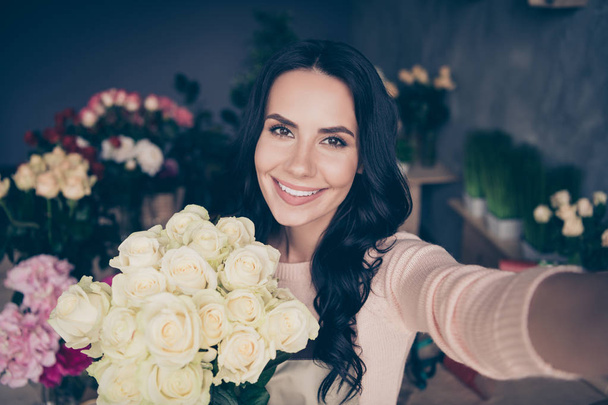 Self-portrait of nice-looking charming attractive gorgeous cheerful wavy-haired lady with perfect desirable birthday celebratory summer spring flavor white roses concrete wall workplace - Φωτογραφία, εικόνα