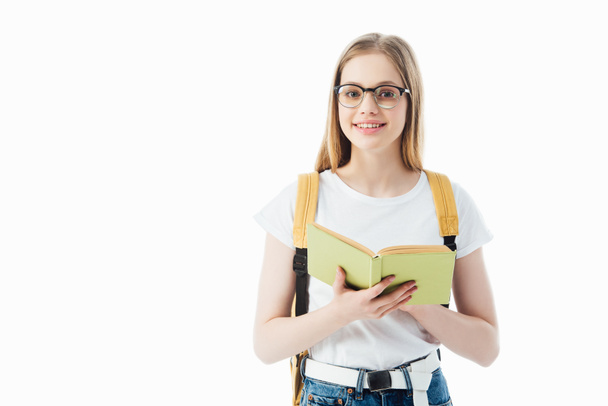 smiling schoolgirl with backpack holding book isolated on white - Valokuva, kuva