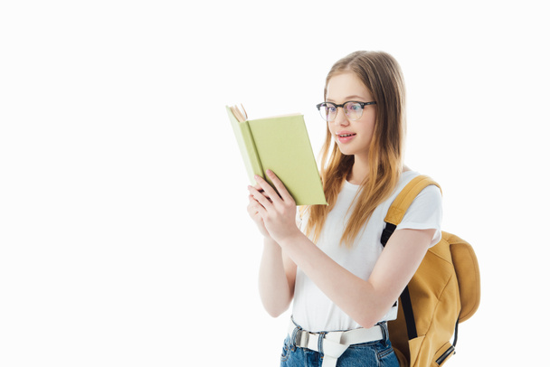 excited schoolgirl with backpack reading book isolated on white - Fotografie, Obrázek