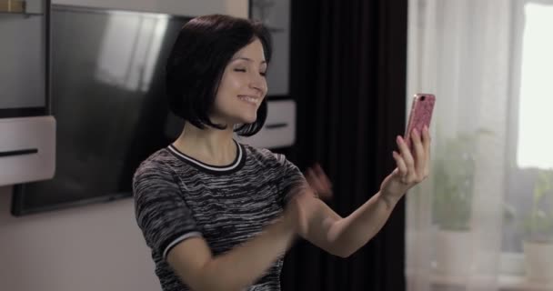 Femme ayant chat vidéo à l'aide d'un smartphone appréciant bavarder avec un ami
 - Séquence, vidéo