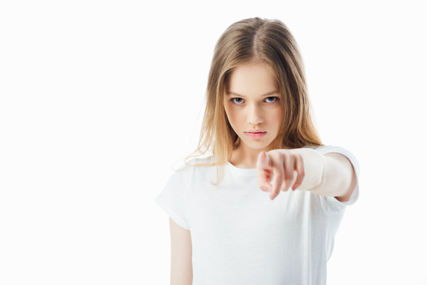 selektivní zaměření uražená mladá dívka ukazující prstem na kameru izolovaná na bílém - Fotografie, Obrázek