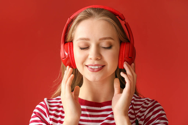 Beautiful young woman listening to music against color background - Photo, Image