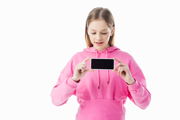 Teen κορίτσι με ροζ κουκούλα κρατώντας smartphone με κενή οθόνη απομονώνεται σε λευκό - Φωτογραφία, εικόνα