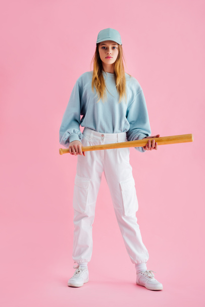 full length view of teenage girl in cap holding baseball bat on pink - Fotografie, Obrázek