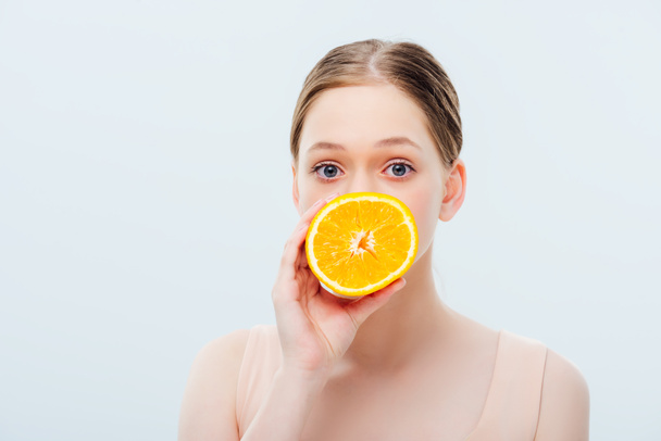 teenage girl with obscure face holding ripe orange half isolated on grey - Φωτογραφία, εικόνα