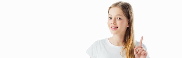 πανοραμική βολή του Happy έφηβο κορίτσι δείχνοντας χειρονομία ιδέα και κοιτάζοντας την κάμερα απομονώθηκε σε λευκό - Φωτογραφία, εικόνα