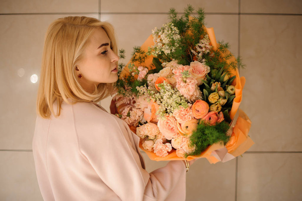 Girl holding bouquet with various orange flowers - Fotografie, Obrázek