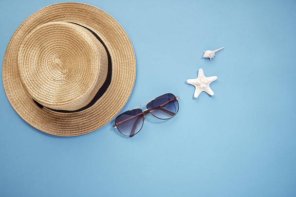 sombrero teléfono inteligente y gafas de sol fondo azul
 - Foto, Imagen