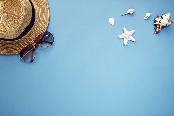 sombrero teléfono inteligente y gafas de sol fondo azul
 - Foto, imagen