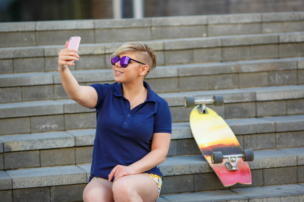 stylish girl in sunglasses takes a selfie - Foto, Imagem