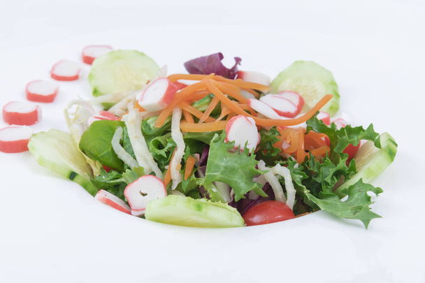 Salada de brotos variada com cebolas cenoura desfiada, tomates cereja em uma chapa de vidro. Fundo branco
 - Foto, Imagem