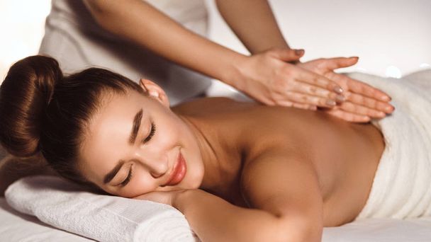 Woman Enjoying Relaxing Back Massage In Spa Centre - Photo, Image