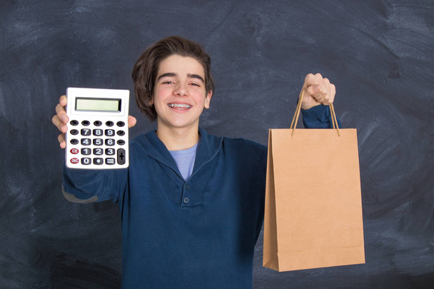 mladý s kalkulačkou a taškou, nakupování a ekonomika - Fotografie, Obrázek